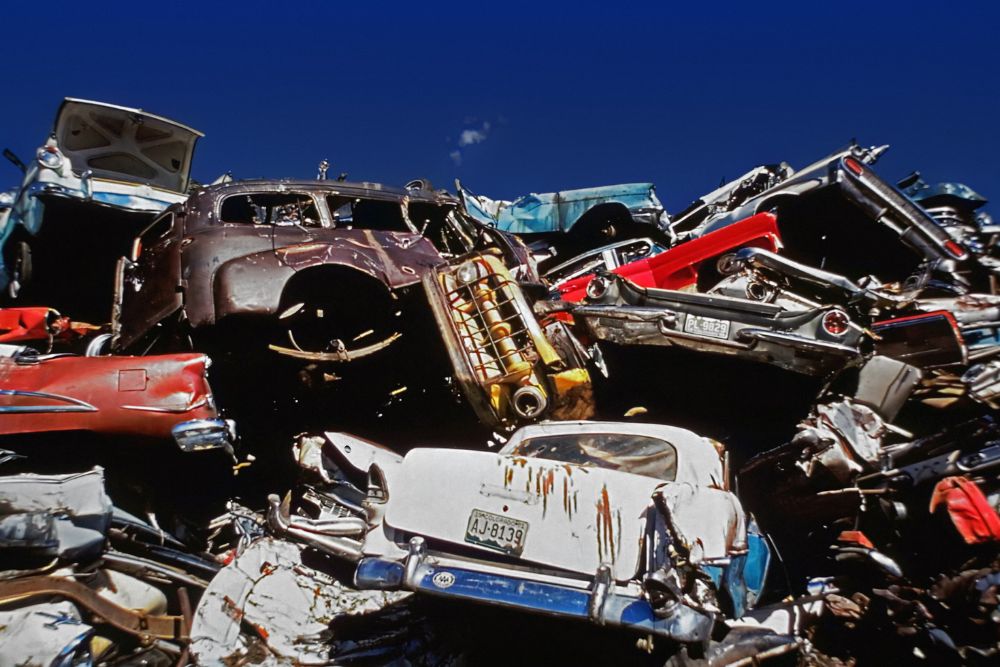 An assortment of old cars and trucks stacked haphazardly, depicting a junk removal service in San Jose, CA.