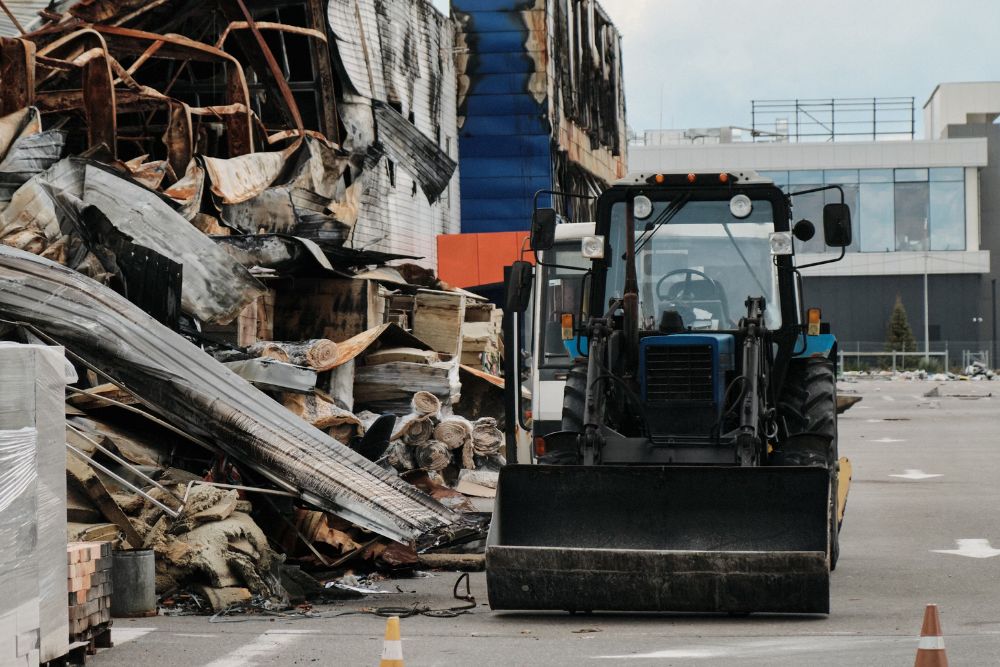 A bulldozer stands idle before a building, representing demolition and tear down services in San Jose, CA.